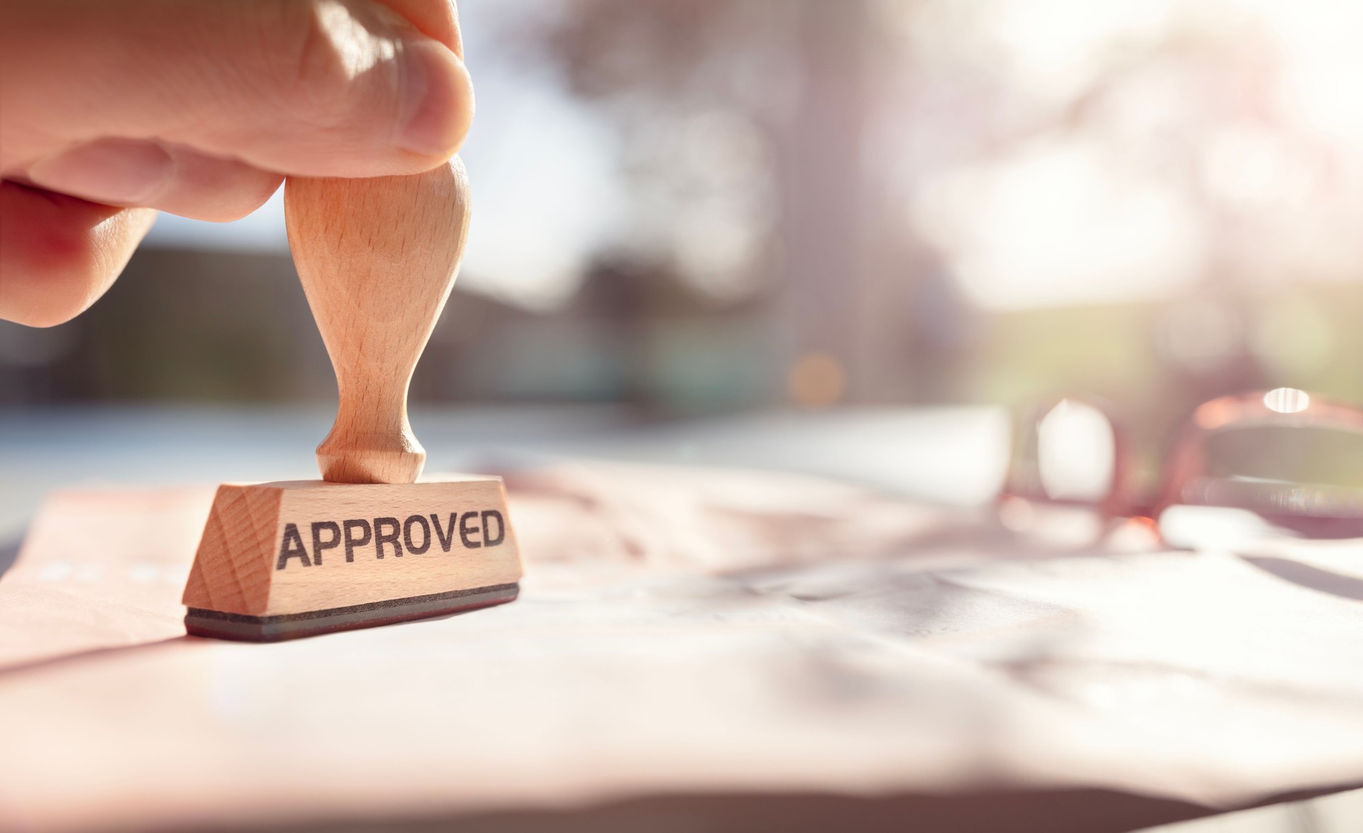 Businessman stamping approved stamp on document in meeting